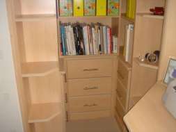 Open wing end shelves with drawers and bookcase fitted into an alcove