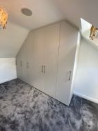 Hinged wardrobes fitted into the gable end of a loft conversion (angled view)