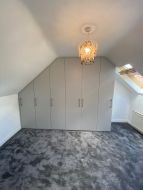 Hinged wardrobes fitted into the gable end of a loft conversion (straight on view)