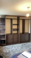 Fitted hinged wardrobe with open end shelves before doors