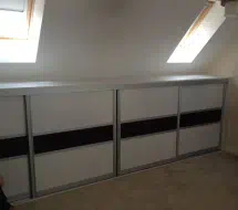 Small lidded wardrobe to fit into the eaves of the room, in fineline white and black