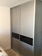 Sliding wardrobe with 2 thirds to 1 third split with black glass as the divider, installed in Yarm